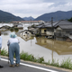An elderly couple looks at a flooded area after heavy rain in Kurashiki, Okayama prefecture, in July 2018.